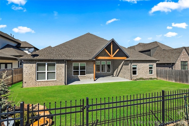 back of property with brick siding, a yard, and a fenced backyard