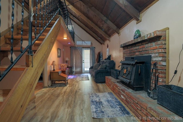 living area featuring beam ceiling, stairway, wood finished floors, and wooden ceiling