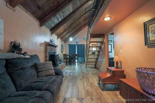 living area featuring a brick fireplace, stairs, beam ceiling, wooden ceiling, and wood finished floors