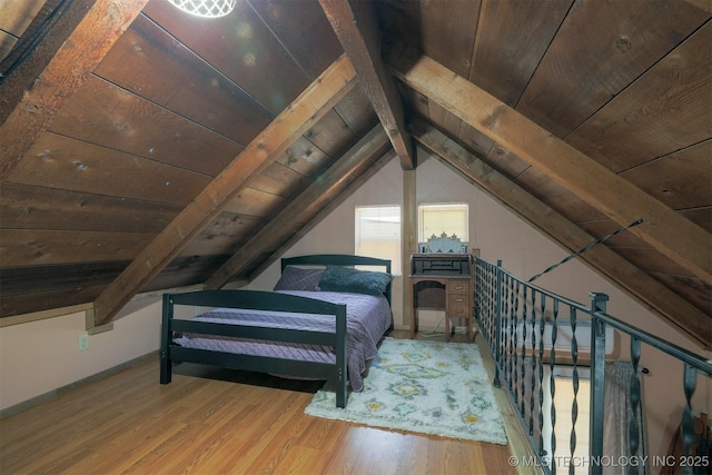 bedroom with vaulted ceiling with beams, wood finished floors, and wooden ceiling