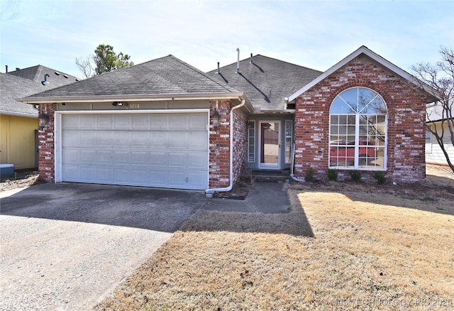 single story home featuring brick siding, driveway, an attached garage, and roof with shingles