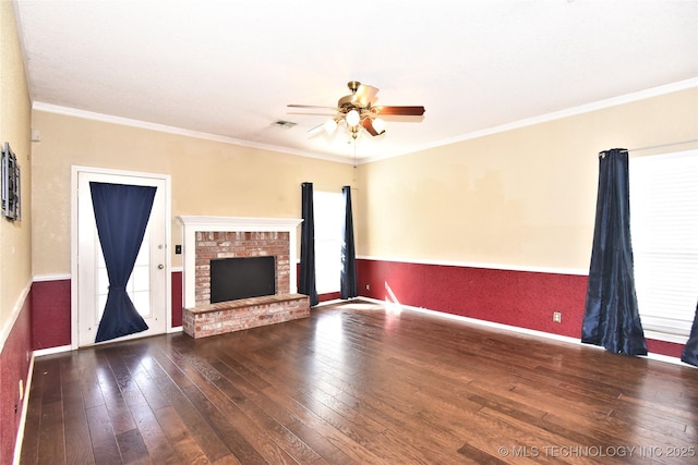 unfurnished living room with visible vents, wood-type flooring, a brick fireplace, and crown molding