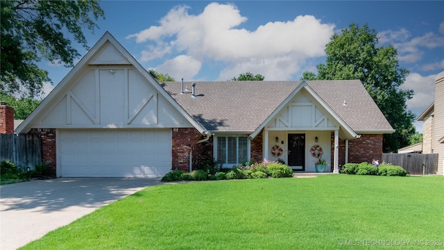 tudor home featuring driveway, fence, roof with shingles, a front yard, and brick siding