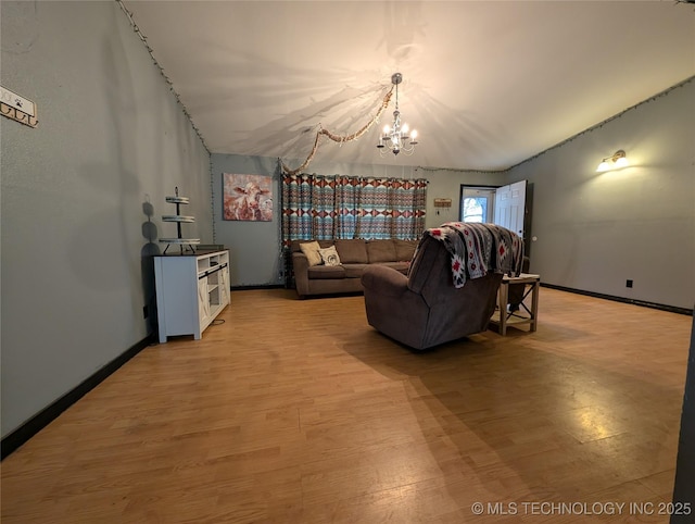 living room featuring baseboards, a notable chandelier, and light wood finished floors