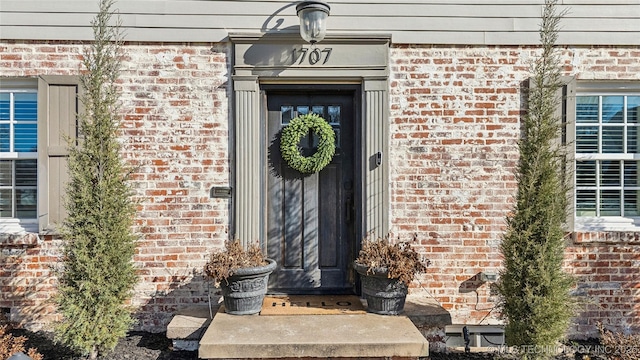 entrance to property featuring brick siding