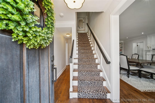 entryway with stairway, wood finished floors, and ornamental molding