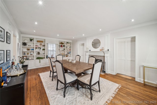 dining room featuring recessed lighting, a fireplace, wood finished floors, and ornamental molding