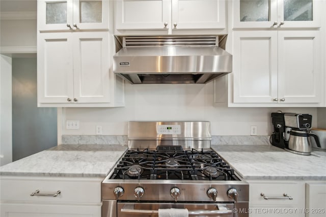 kitchen with range hood, white cabinets, glass insert cabinets, and stainless steel gas range oven