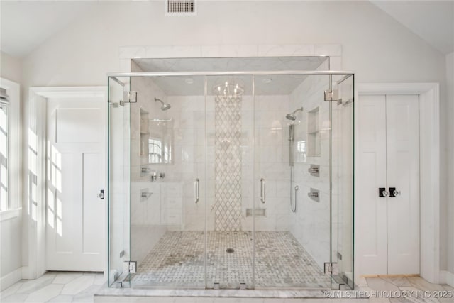 full bathroom with visible vents, a shower stall, and vaulted ceiling