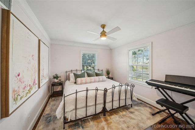 bedroom featuring multiple windows, ceiling fan, baseboards, and wood finished floors