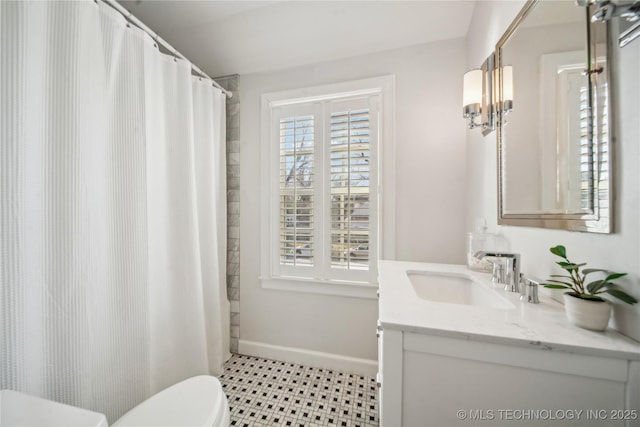 bathroom featuring a shower with curtain, baseboards, toilet, and vanity