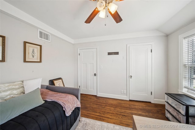 bedroom with visible vents, baseboards, lofted ceiling, and wood finished floors