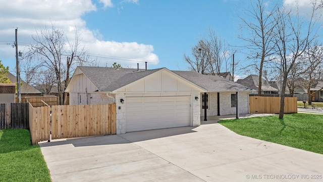 view of front facade featuring stone siding, board and batten siding, an attached garage, and fence