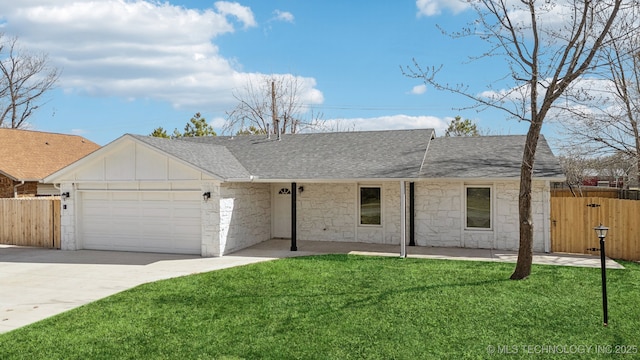 ranch-style home with an attached garage, a shingled roof, a front lawn, and fence