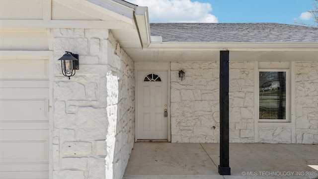 property entrance with stone siding and roof with shingles