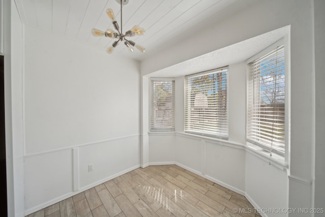 unfurnished dining area with a wealth of natural light, light wood-style flooring, and a decorative wall