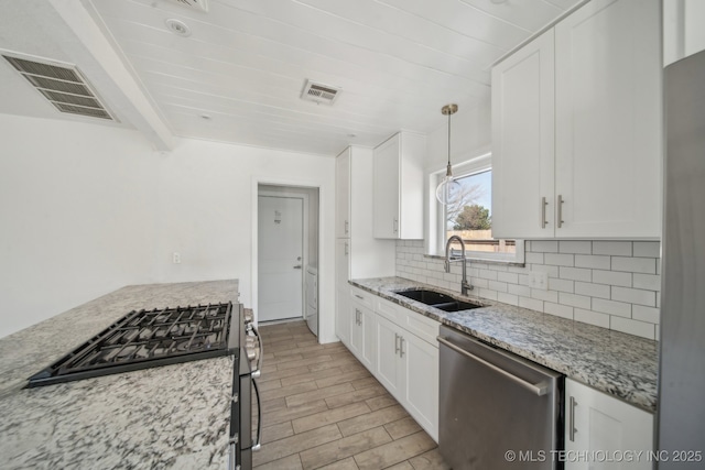 kitchen featuring a sink, visible vents, appliances with stainless steel finishes, and decorative backsplash