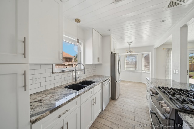 kitchen featuring white cabinets, visible vents, appliances with stainless steel finishes, and a sink