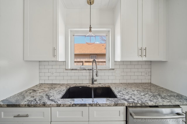 kitchen featuring decorative backsplash, dishwashing machine, white cabinets, and a sink