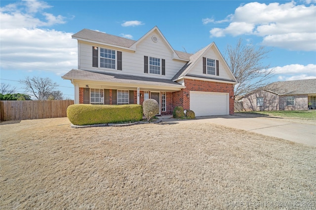 traditional-style house with an attached garage, fence, brick siding, and driveway