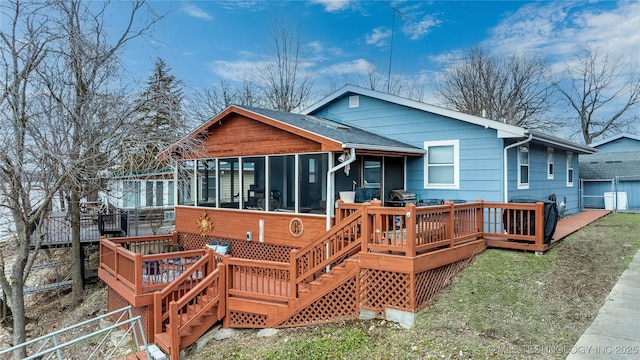 rear view of property with a deck, stairway, fence, and a sunroom