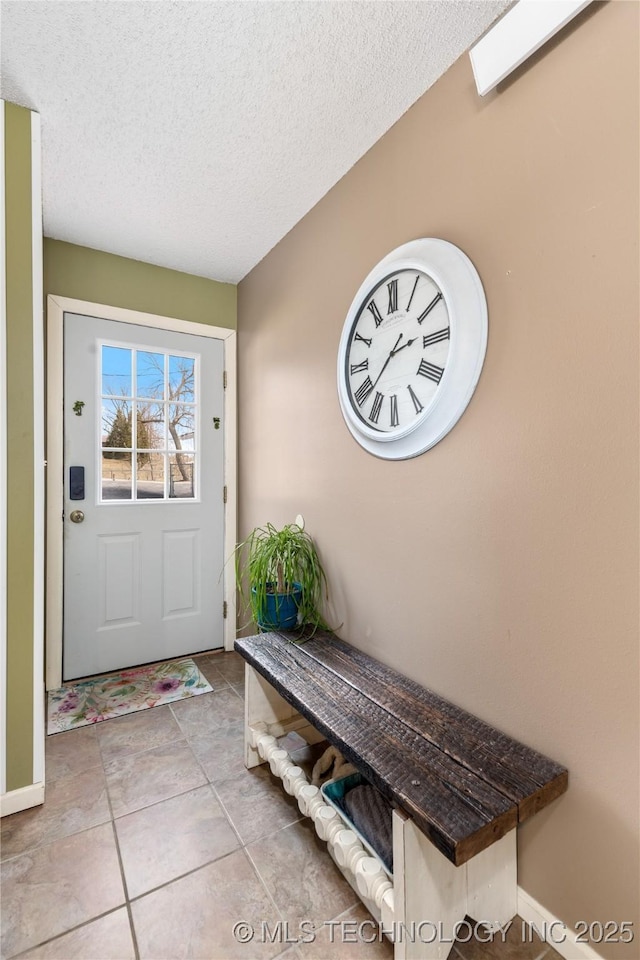 entrance foyer with tile patterned flooring, baseboards, and a textured ceiling