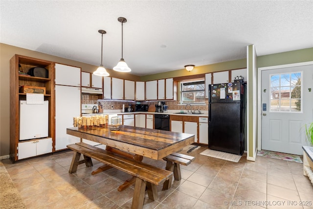 kitchen featuring under cabinet range hood, black appliances, light countertops, and a sink