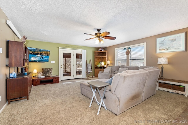 living room with light colored carpet, french doors, a textured ceiling, and a ceiling fan