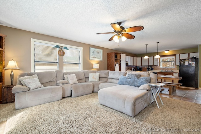 living room with a textured ceiling, tile patterned floors, and ceiling fan