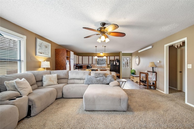 living room featuring a textured ceiling, a ceiling fan, and light carpet