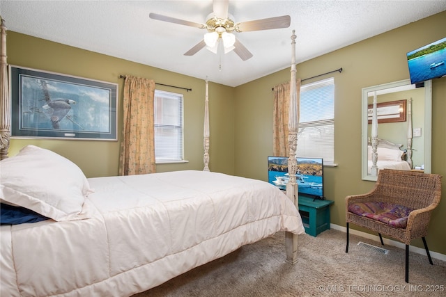 bedroom featuring visible vents, a textured ceiling, carpet flooring, baseboards, and ceiling fan