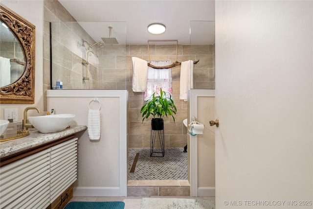 bathroom with tile patterned floors, baseboards, vanity, and walk in shower