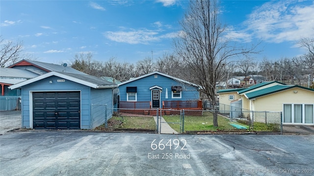 view of front of property featuring a gate, a fenced front yard, and aphalt driveway