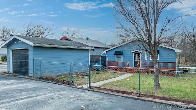 single story home featuring a front lawn, fence, a garage, and an outbuilding