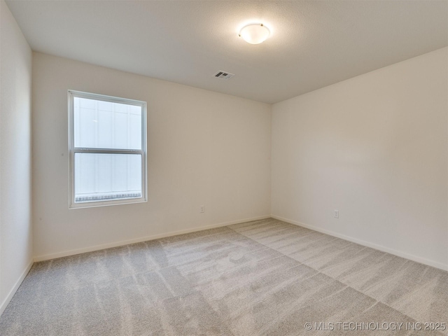 carpeted empty room with visible vents and baseboards