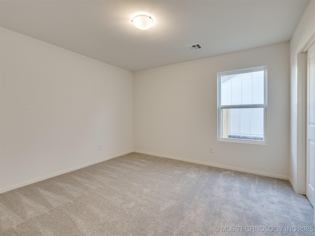 carpeted spare room with baseboards and visible vents