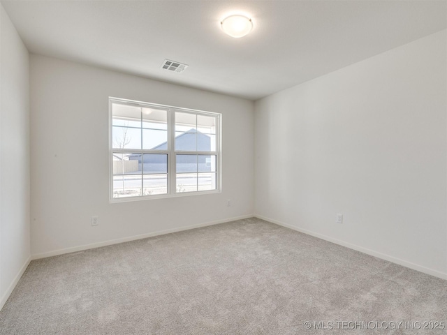 carpeted empty room featuring baseboards and visible vents