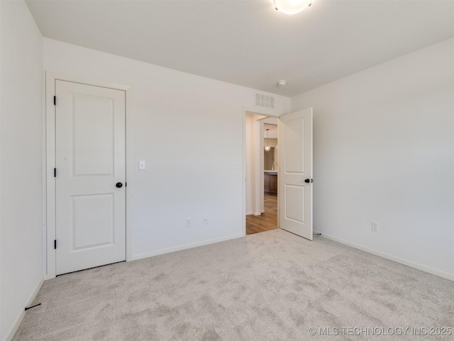 unfurnished bedroom featuring baseboards, visible vents, and carpet floors