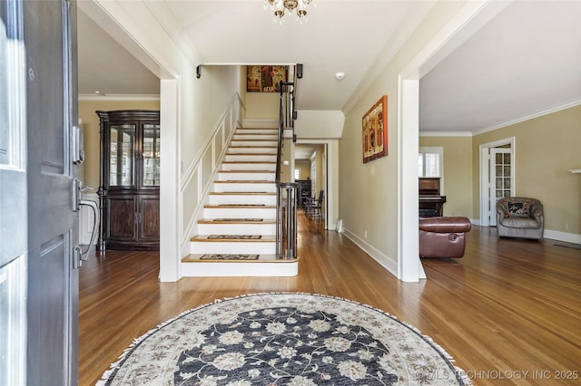 foyer featuring stairs, a healthy amount of sunlight, wood finished floors, and crown molding