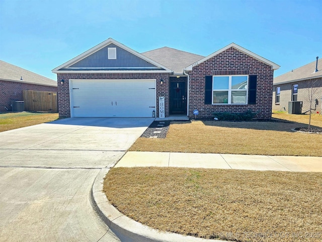 single story home featuring a front yard, an attached garage, concrete driveway, central air condition unit, and brick siding