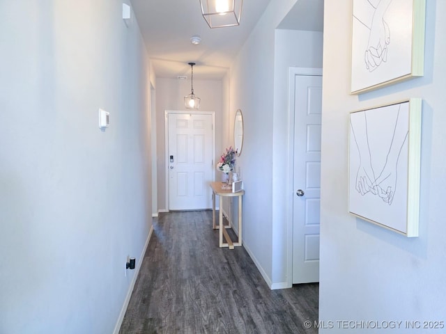 hallway featuring baseboards and dark wood-style floors