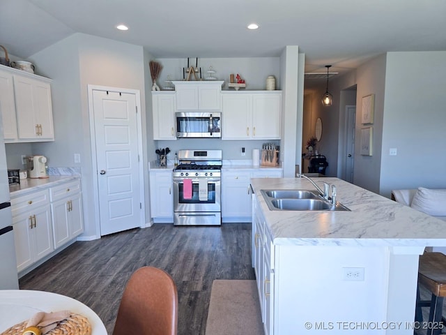 kitchen featuring a breakfast bar, dark wood finished floors, white cabinetry, recessed lighting, and appliances with stainless steel finishes