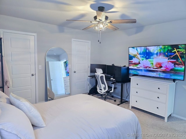 bedroom featuring arched walkways, light colored carpet, and a ceiling fan