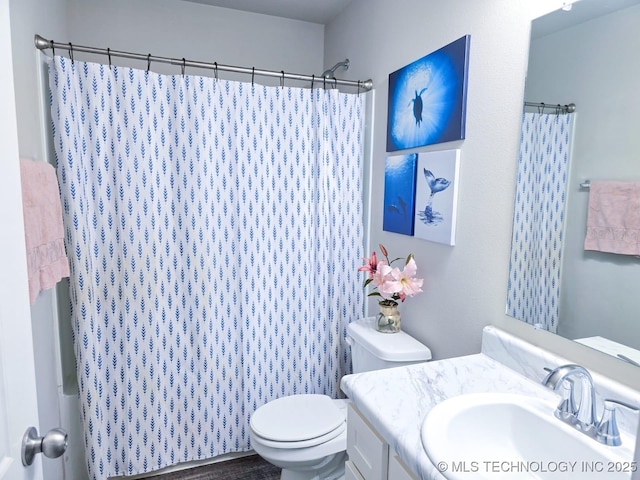 bathroom featuring curtained shower, toilet, and vanity