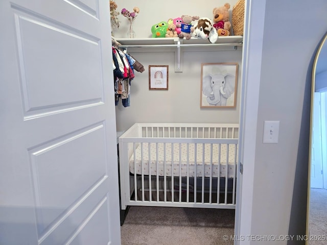 interior space with a crib and carpet