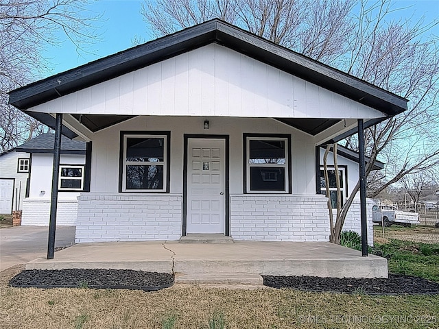 view of front facade with a porch and brick siding