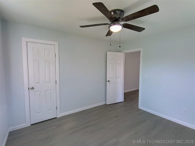 empty room featuring ceiling fan, baseboards, and wood finished floors