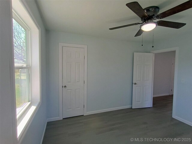 unfurnished room with baseboards and wood finished floors