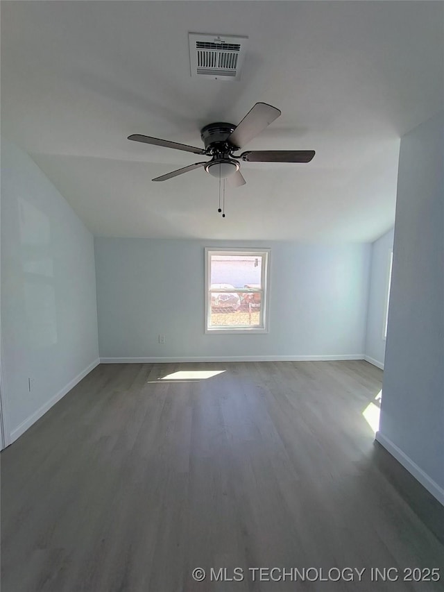 spare room with visible vents, a ceiling fan, baseboards, and wood finished floors