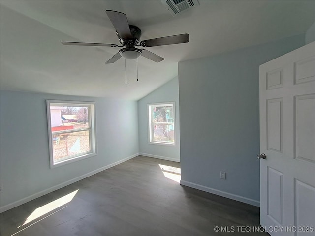 unfurnished room with visible vents, lofted ceiling, wood finished floors, baseboards, and ceiling fan